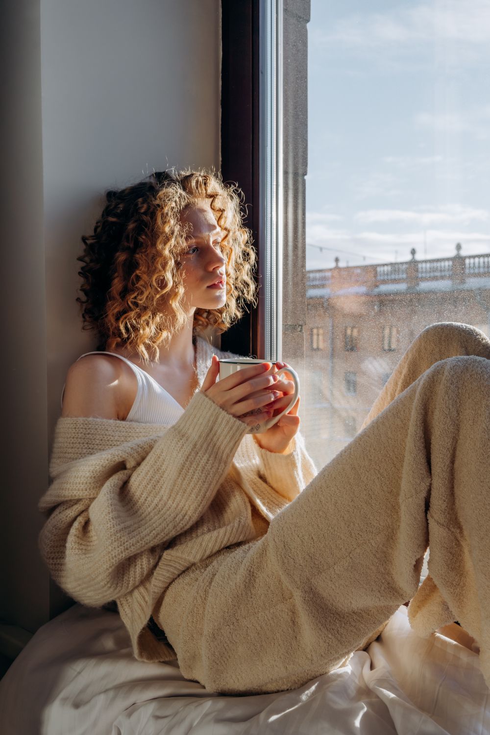 Mesa junto a una ventana con una taza, iluminada por la luz suave de la mañana